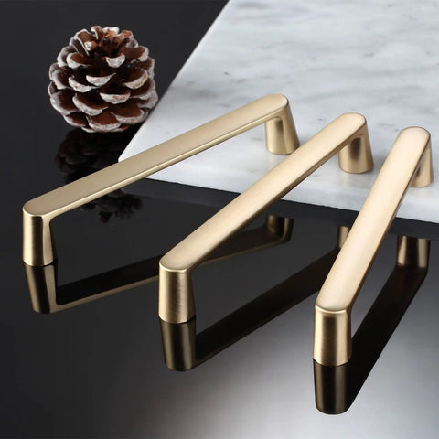 Brushed Brass Cabinet Pulls 7 Inch Length 6.3 Inch Center To Center Gold Handles on black surface with pine cone
