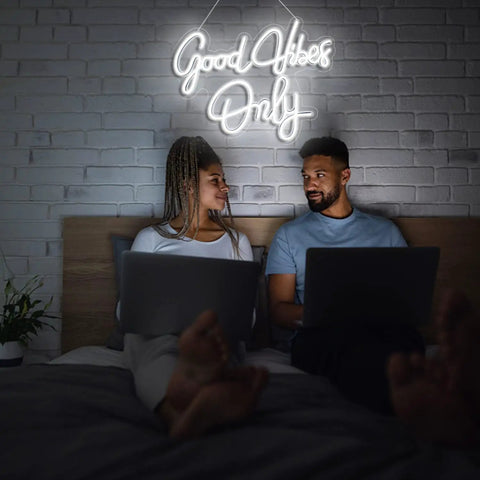 Couple under 'Good Vibes Only Neon Sign Wall Decor White Neon Light For Bedroom Bar Wedding Engagement Christmas Valentine’s Day Birthday Party 16.9 x 9 Inch Clear Acrylic Neon Strip Light' on wall