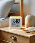 Chill Vibes Digital Alarm Clock Displays Time On A Watercolor Lemon Botanical Cube on bedside table with book, 80mm size.