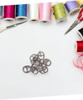 Handy Mini Buckle Sewing Kit 150 Piece Set for Doll Clothes and DIY Craft Projects on a crafting table with tools and threads.