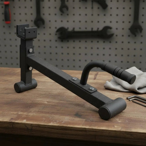 Heavy Duty Barbell Plate Lifter And Plate Change Jack with curved handle on wooden table in workshop setup.