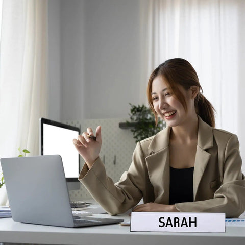 Office desk showing a 20 Pack Acrylic Desk Name Plates 2 By 10 Inch Clear Plastic Name Tent Holders with 'Sarah.'