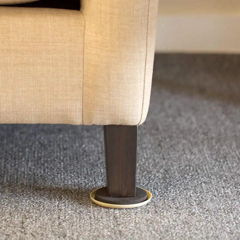Heavy Duty Round Plastic Carpet Furniture Sliders Glide Your Couch Tables And Dressers Smooth As Butter Pads 3.5 Inches Wide Four Pack Browns under a sofa leg on carpet.
