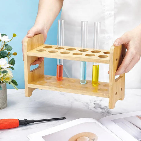 Person holding 12 Hole Test Tube Rack Made From Bamboo Wood Lab Stand For Chemistry Classrooms And Experiments, Features Interchangeable 26mm 27mm And 28mm Trays For Quick Organization And Sleek Display In The Lab.