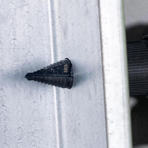 Step Drill Bit With Aluminum Titanium Nitride Coating For Long Lasting Durability drilling through metal surface shown in motion