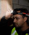 Person wearing a Rechargeable Two Color LED Headlamp With Durable Fabric Strap, illuminating a dark space, showcasing its spotlight mode.
