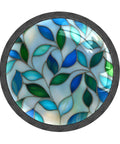 Colorful stained glass design with blue and green leaves inside a circular frame.