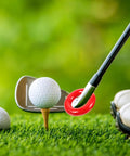 Close-up of a golf club with a Weighted Golf Swing Ring attached, set beside a golf ball on a tee for skill mastery.