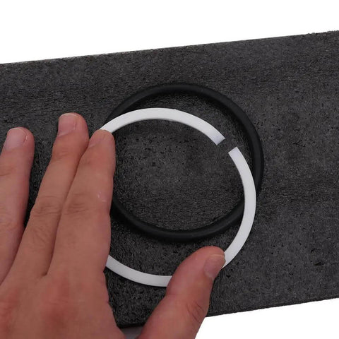 Person holding black and white oil seals on textured surface, part of 6-Piece Set Hydraulic Punching Square Dies For CH-70 Punching Machine