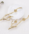 Slick Twig Drawer Pulls In Polished Brass Plum Blossom Branch Handle For Cabinets And Dressers resting on white surface