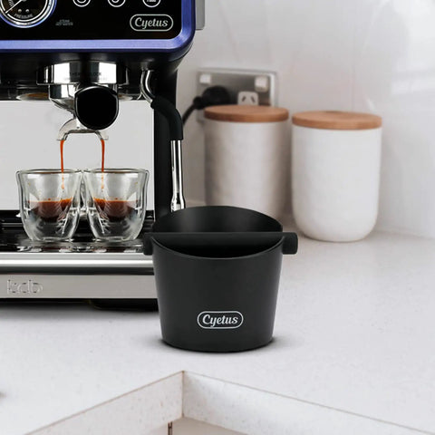 Espresso Knock Box With Silicone Rod And Anti Slip Base shown on a kitchen counter beside an espresso machine