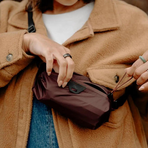 Person holding Ultralight Terra Shell Packing Cube Weatherproof Luggage Organizer, size S, in brown, attached to coat