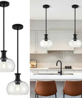 puncoll 2 PK 9 Inch Modern Black Clear Glass Pendant Light with clear glass shades in a stylish kitchen setting.
