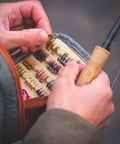 Person selecting fly fishing lure from Canyon Creek Chest Pack 2L Lightweight 420D Nylon Gray 9 x 5 x 4.5 Inches Weighs 1 Pound
