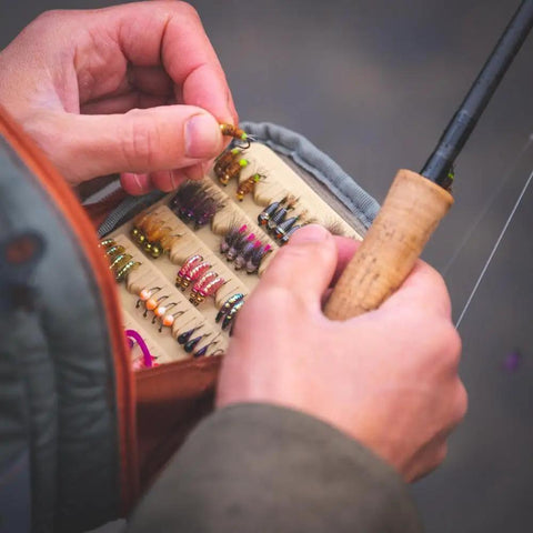 Person selecting fly fishing lure from Canyon Creek Chest Pack 2L Lightweight 420D Nylon Gray 9 x 5 x 4.5 Inches Weighs 1 Pound