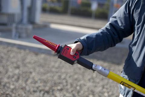 Field tech using High Voltage Detector Kit For Field Techs 30 V To 122 kV AC Intrinsically Safe Pro Grade MSHA Certified Push Button Self Test Hot Stick Included Amprobe TIC 300 PRO For Transmission Lines And Power Distribution Equipment.