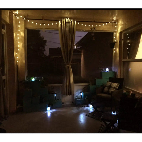 Cozy patio with Battery Operated 25 Feet 100 LED Warm White Hanging String Lights With 20 Bulbs Remote Dimmable Eight Modes Memory Timer Waterproof And Shatterproof For Indoor Outdoor Decor Perfect For Bedroom Patio Balcony Home And Christmas Party illuminating the space.