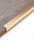 Sharp Matte Gold Peel And Stick Corner Guards Shield Walls And Drywall Hassle Free Heavy Duty Aluminum L Trim on wood surface.