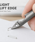 Close-up of Mini Pencil EDC Pendant with Infinite Keychain lifting staple, demonstrating pocket-sized writing tool use for small tasks.