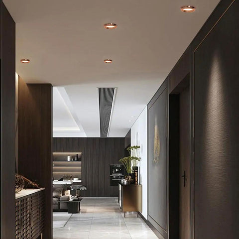Recessed lighting in a stylish corridor with rose gold trim and modern decor, showcasing saditesdk 15 Pack Recessed Lighting Housing Trim Kits.