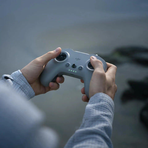 Hands holding the FPV Remote Controller 3 for O4 video transmission, featuring lightweight design and extended sticks for precise control.