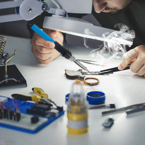 Person using 60W Soldering Iron Kit With Adjustable Temperature and 13 in 1 Pro Grade Electronics Tool Set on circuit board.