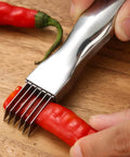Stainless steel scallion cutter with multiple blades pressing into a red pepper on a wooden cutting board