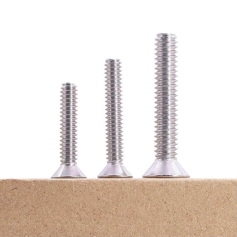 Three sizes of 1/4-20 Flat Socket Cap Screws, 2-1/2 Inch Long, Full Thread, Countersunk Head, 304 Stainless Steel 18-8 on a wooden surface