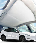 Tesla Model Y sunshade: gray double-layer glass with clips over panoramic roof.