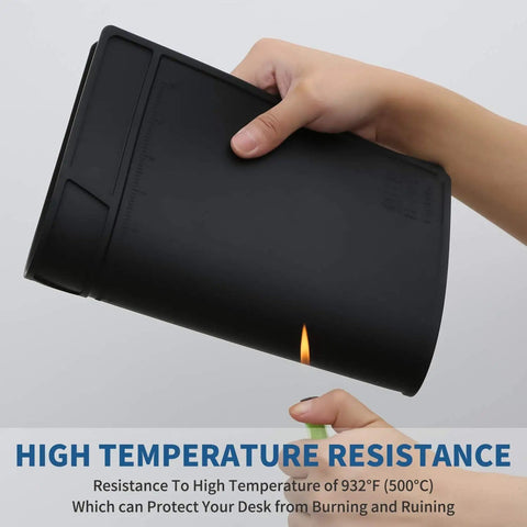 Person holding rolled Black Silicone Soldering Mat For Electronic Repairs, showcasing heat resistance against flame