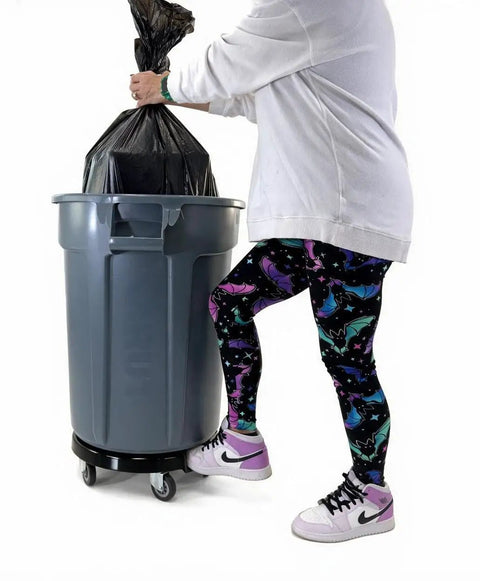 Heavy Duty Trash Can Dolly With Five Casters And Foot Stabilizer Plastic Utility Cart That Fits 20 To 55 Gallon Brute Containers Supports Up To 460 Lb Durable Black Finish For Easy Transport holding a 20-55 gallon trash can