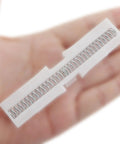 Two Piece White ABS Sliding Guide Rails Kit For Double Folding Doors Top Track Hardware in hand, showcasing spring mechanism.