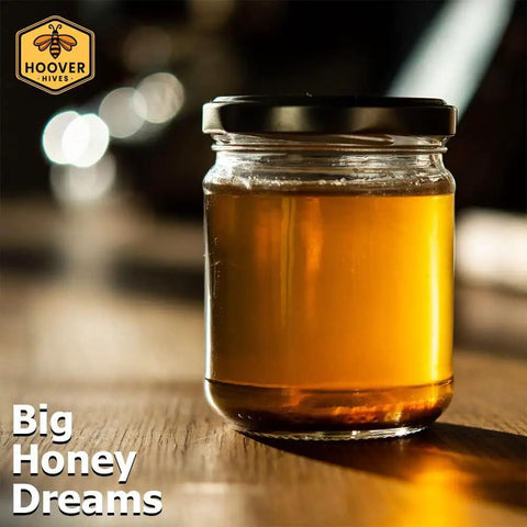 Glass jar of honey on wooden table with branding.