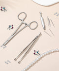 9 Piece Stainless Steel Piercing Tool Kit With Ball Grabber And Clamps For Easy Jewelry Changes, tools laid out on a table.