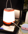 USB Rechargeable Night Light For Kids, Portable Camping Lantern glowing on a laptop, pink with handle, charging cable visible
