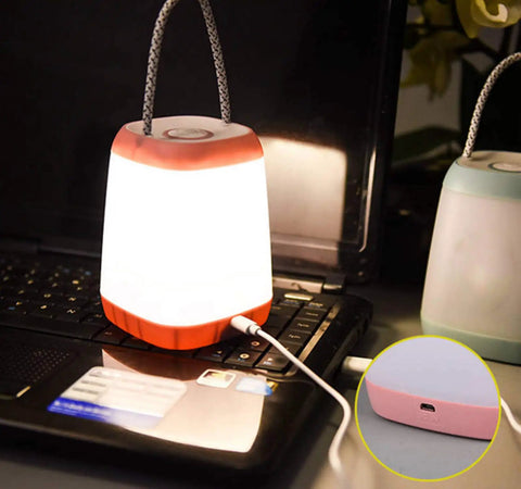 USB Rechargeable Night Light For Kids, Portable Camping Lantern glowing on a laptop, pink with handle, charging cable visible