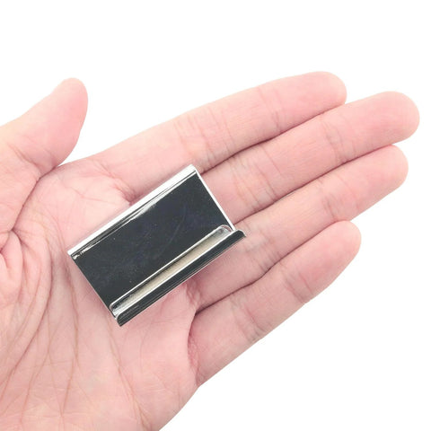 Hand holding stainless steel clip, 1.6 inches long and 0.75 inches wide, part of Glass Door Clip On Handles 4 Pack for 5-6 mm glass.