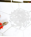 Pro Grade Nylon Hidden Fasteners For Wood Shelves And Cabinets 100 Pack on a work surface with pliers.