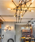 Industrial room with T10 LED Long Bulbs 4W Dimmable Tubular Filament Bulbs in chandelier and wall fixtures, warm ambiance.