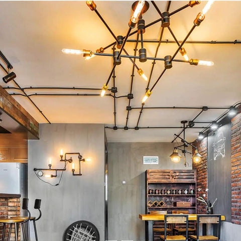 Industrial room with T10 LED Long Bulbs 4W Dimmable Tubular Filament Bulbs in chandelier and wall fixtures, warm ambiance.