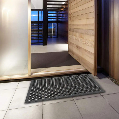 Grippy Non Slip Rubber Drainage Floor Mat With Holes 24x36 Anti Fatigue Cushion placed in a modern entryway over tile flooring.