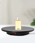 Smooth Electric Rotating Display Stand 360 Degree Turntable with Pure Copper Motor showcasing a bottle of shower gel on a sleek black platform.