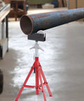 Beefy Portable High Pipe Stand With Roller Head in workshop holding a metal pipe on uneven floor
