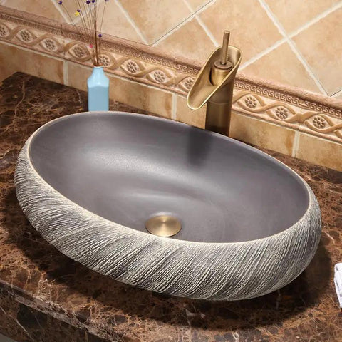 USZWBY Vessel Sinks Bathroom Vessel Sink Washbasin Ceramic Art Countertop Basin round sink with textured edges on a marble countertop.