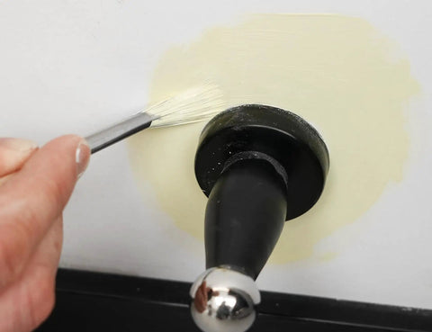 Person using Score Big On Crisp Trim Lines With This 4 Piece Paint Brush Set on wall around a doorknob.