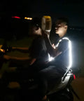 Two people on a scooter at night, one holding a Dual-Mode Portable Wind And Water Turbine Generator For Outdoor Power Small Hydroelectric Micro Turbine.