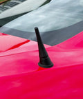 Close-up of a red car with 3.8 Inch Aluminum Antenna Mast Replacement For Mustang 2010-2014, Transit 2013-2022, Lincoln MKZ 2013-2019, Ford Compatible Car Wash Proof Antenna Mast For Reliable Reception And DIY Friendly Install visible on the roof.