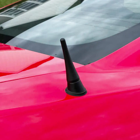 Close-up of a red car with 3.8 Inch Aluminum Antenna Mast Replacement For Mustang 2010-2014, Transit 2013-2022, Lincoln MKZ 2013-2019, Ford Compatible Car Wash Proof Antenna Mast For Reliable Reception And DIY Friendly Install visible on the roof.