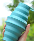 Foldable Silicone Water Bottle For Travel And Gym, ultra lightweight hydration flask held in hand against outdoor background
