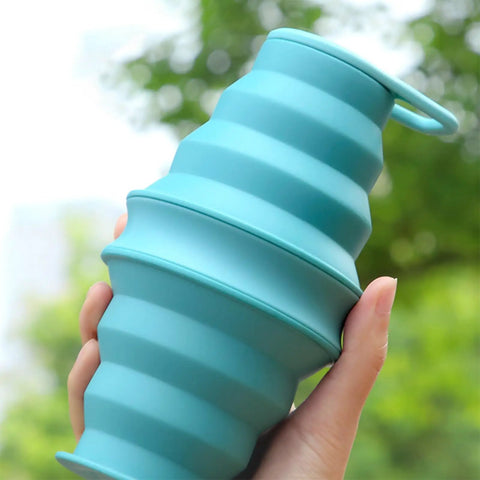 Foldable Silicone Water Bottle For Travel And Gym, ultra lightweight hydration flask held in hand against outdoor background